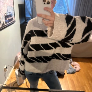 Beige och svart randig tröja - Säljer en mysig beige tröja med svarta ränder. Tröjan har en loose passform och långa ärmar, perfekt för kyligare dagar. Den är tillverkad i ett mjukt material som känns skönt mot huden.