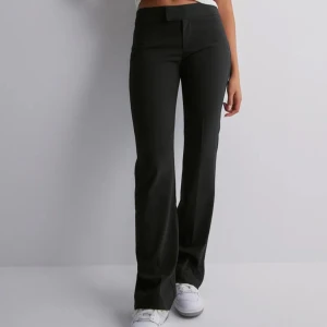 Svarta kostymbyxor - Säljer mina lågmidjade kostymbyxor från Nelly. Lappen med storlek saknas men skulle säga att det är en 32☺️💕(byxorna är lite noppriga men inget man tänker på) skickar bilder om det behövs! 