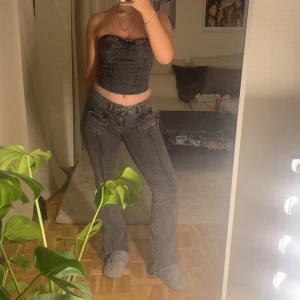 Grå bootcut jeans med fickor - Säljer ett par grå tvättade jeans med bootcut-modell och stora fickor framtill. Jeansen har hög midja och raka sömmar längs benen. Snygg vintagekänsla och passar perfekt till crop tops eller hoodies.