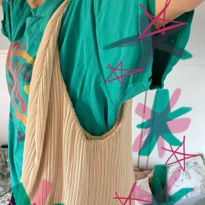 Beige plisserad axelväska - Säljer en stor och mjuk axelväska i beige med plisserad design. Köpt från Zara! Väskan har en bred axelrem och rymligt huvudfack, perfekt för att få plats med allt du behöver. Materialet känns lätt och smidigt, och den neutrala färgen gör den enkel att matcha. Knappt använd:) skriv för frågor:)  köparen står för frakt.