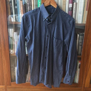 Blårutig skjorta från Ralph Lauren - Snygg blårutig skjorta från Ralph Lauren i 100% bomull. Skjortan har klassisk krage, knäppning framtill och en bröstficka. Perfekt för dig som gillar stilrena och tidlösa plagg med en modern touch.