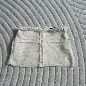 Minikjol - Krämvit kjol från Zara som är klippt kortare  med fina guld detaljer framtill🤍passar XS-S