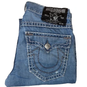 True Religion jeans - True Religion jeans Jack fit. W34. Lagad heelbite som syns på andra bilden. [Ytterbenslängd 112cm] [Innerbenslängd 86cm] [Midja 46cm] [Benöppning 22cm] de har ett hål vid knät på vänsterbenet som är ganska stort men bara o sy ihop 