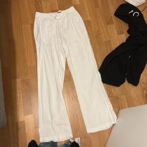 Vita linnebyxor med snörning XS - Säljer ett par vita linnebyxor. Byxorna har elastisk midja med snörning, raka ben och fickor både fram och bak. Perfekta för chill dagar eller när du vill ha en clean och luftig look. Aldrig använd