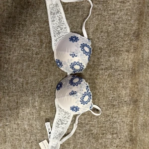 Intimissimi BH - Superfin bh från Simona i vitt med blå broderade blommor på kuporna och breda spetsdetaljer på sidorna. Justerbara axelband och klassisk knäppning bak. Aldrig använt har tom prislappen kvar! 💞💞💞
