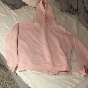 Ljusrosa hoodie från Gina Tricot XS - Mysig ljusrosa hoodie från Gina Tricot, basically basics-kollektionen. Klassisk modell med huva och känguruficka framtill. Perfekt för chill dagar och enkel att matcha med jeans eller leggings.