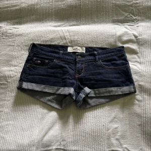 Mörkblå jeansshorts från Hollister - Snygga mörkblå jeansshorts från hollister. I storlek w26. Dom är som helt nya. Då dom är lite för stora för mig har jag inte använt dom. Hör av er om ni har några frågor💕