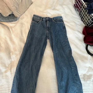 Mörkblåa jeans från HM - Blåa jeans från Hm med fram passform i storlek 32/32. Jeansen har fem fickor, bälteshällor och knappgylf. 
