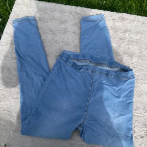 Ljusblå jeansleggings från Cellbes - Säljer ett par ljusblå jeansleggings från Cellbes med elastisk midja för extra komfort. Byxorna har en slim passform och är tillverkade i stretchigt jeansmaterial. Perfekta för dig som gillar en enkel och clean look.