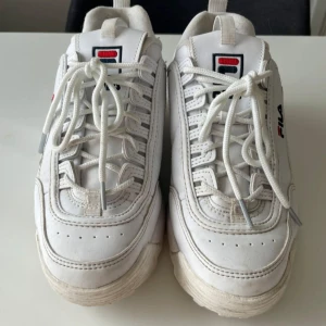 Vita chunky sneakers från Fila - Säljer ett par klassiska vita Fila Disruptor sneakers med chunky sula och snörning, Storlek 39. Knappt använda, hela och rena Inköpa på zalando