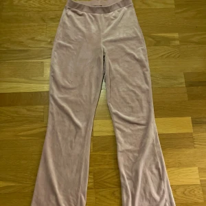 Ljusrosa mjukisbyxor i velour - Supermjuka ljusrosa mjukisbyxor i velour med bootcut-ben och resår i midjan. Byxorna har två bakfickor och en skön loose passform, perfekta för chill dagar eller när du vill vara extra bekväm.