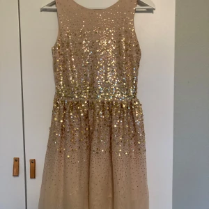H&M guld paljett klänning - En söt balklänning from H&M! Ett par år gammal men jag har bara använt den 2 ggr, eftersom den sitter lite stort på mig. Skriv för flera bilder, det var lite dåligt ljus i bilderna 💛