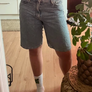 Ljusblå jeansshorts från Cava Company - Säljer ett par ljusblå jeansshorts från Cava Company, Junkyard,  i klassisk bermuda-modell med fem fickor och normal till lösare passform. Shortsen har midwaist och är tillverkade i jeansmaterial, perfekta för sommaren. Snyggt avslappnad look som funkar till allt.