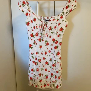 Vit blommig klänning från Zara - Jättesöt vit klänning med röda blommor från Zara. Perfekt nu till sommaren! Passar XS/S. 