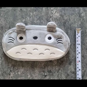 Totoro plysch pennskrin/pennfodral - Söt grå plysch pennskrin med dragkedja och djuransikte framtill, inspirerad av Totoro. Mjukt material och öron upptill. Perfekt för småsaker eller mynt.