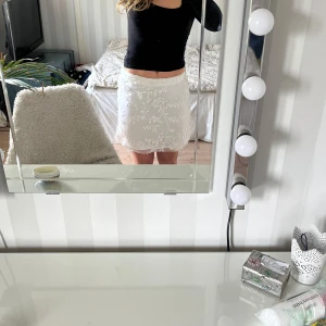 Vit spetskjol från BikBok - Supersöt vit kjol från BikBok med broderade blommor i spets. Kjolen är kort och har en feminin look med fina detaljer. Perfekt att styla med en enkel topp för en fräsch outfit.💕