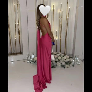 Rosa balklänning från KLAOA - Säljer en rosa långklänning från KLAOA med öppen rygg💞. Klänningen har en halterneck-ringning kch perfekt till bal! Den är ursprungligen i e storlek M men har sytts in för att passa en XS/S. Klänningen är endast använd 2 gånger. 