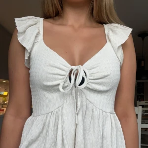 Vit topp med volangärmar - Supersöt vit topp med volangärmar och knytning framtill. Från Lager 157 och är i storlek S! Perfekt för varma dagar 💗