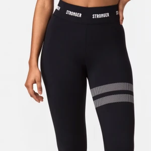 Svarta träningstights från Stronger - Svarta tights från Stronger med hög midja och elastisk linning med logga. Snygga vita ränder med prickigt mönster på ena benet. Oanvända💕