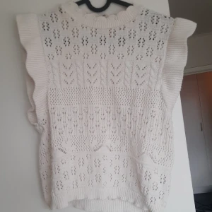 Vit stickad topp från ONLY - Supersöt vit stickad topp från ONLY i storlek S med volangdetaljer på axlarna och vackert hålmönster. Tryck gärna på köp nu🌸