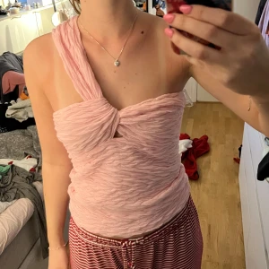 Ljusrosa off shoulder topp  - Säljer en ljusrosa one shoulder topp som är perfekt för sommarfester! Så fin och har ett bra tjockt material.