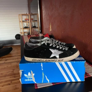 Svarta sneakers från Golden Goose med silverstjärna - Säljer ett par svarta Golden Goose sneakers i svart mocka med en stor silverfärgad stjärna på sidan och grå snörning i storlek 44. Unika, stilrena och perfekta nu till den kommande vår och sommarperioden. För mer bilder och vidare intresse kom privat.
