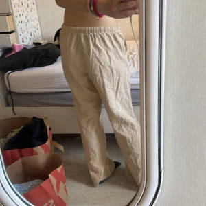 Beiga linnebyxor med dragsko - 30kr Säljer ett par beiga linnebyxor med resår i midjan och dragsko. Byxorna har raka ben och sidofickor, perfekta för en avslappnad stil. Lätta och luftiga, passar bra till varmare dagar.