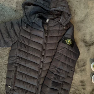 Grå pufferjacka från Stone Island - Säljer en svart pufferjacka från Stone Island den har legat i min garderob i 2 år men är i jätte bra skick