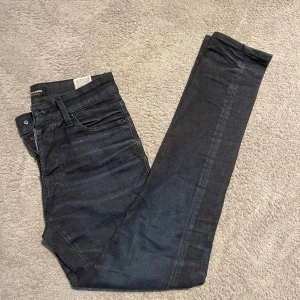 Mörkblå Jack and Jones jeans - Snygga mörkblå Jack and Jones jeans i storlek 30/32 i modellen Glenn. Det är även en twisted modell, så hör av er vid minsta fundering! Helt nya utan tagg och nypris ligger på runt 800, mitt pris endast 199!