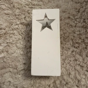 Ljuslykta  -  vit fyrkantig ljusbehållare med utskurna stjärnor.