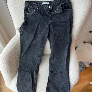 Svarta lågmidjade straight jeans från NA-KD - Säljer ett par svarta jeans från NA-KD i storlek 36. De har en klassisk femficksdesign, rak passform och dragkedja med knappstängning. Jeansen har en cool tvättad look och är gjorda i jeansmaterial som känns både slitstarkt och bekvämt.Lågmidjade jeans. OBS dragkedjan har blivit lagad en gång ! 