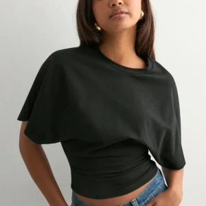 T-shirt - Fin T-shirt från Nelly. Modellen är tajt i midjan och har luftigare armar. Superfin tröja som passar bra till finare tillfällen och vardag. Lite liten i storlek så passar även s. Använd fåtal gånger🩷