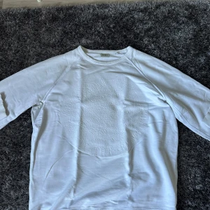 Vit långärmad tröja från Diesel  - Vit långärmad tröja från Diesel i storlek XL. Tröjan har ett diskret, upphöjt mönster framtill med Diesel-logga och är gjord i 100% bomull. Klassisk rund hals och ribbade muddar vid ärmslut och nederkant. Perfekt nu till hösten💪 Storleken är XL men sitter som en L. Anledningen till att jag säljer tröjan är att den ej kommit till användning på det senaste, vid snabb och smidig affär kan priset diskuteras🙂👍