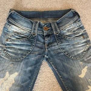 Blå Pepe Jeans Midonna med slitningar - Säljer ett par blå Pepe Jeans Midonna med coola slitningar och tvättade detaljer. Köpte dom på vinter men de var tyvärr för små. Lite slitna i rumpan men går fortfarande att använda. 