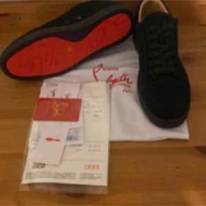 Marinblåa Christian Louboutin sneakers mocka - Säljer ett par svarta sneakers från Christian Louboutin i mjuk mocka med klassisk röd sula. Skorna har rund tå, snörning och platt sula. Snygg och stilren design med diskret logga på hälen. Perfekt för dig som gillar lyxiga detaljer och streetstyle.