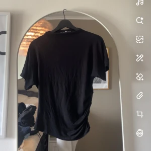 Svart basic t-shirt i bomull - Säljer en jätte fin enkel svart tröja med lite ihop draget på sidan av tröjan pris kan diskuteras 