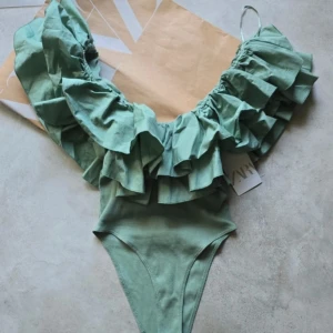 Grön volang body från Zara - Supersnygg grön topp från Zara med breda volanger över axlarna och v-ringad hals. 