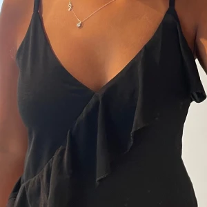 Svart omlottklänning med volang - Snygg svart omlotttopp, finns likadan i VIT!!!!