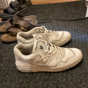Vita New Balance 550 sneakers - Säljer ett par vita New Balance 550 i storlek 43. Inte använt dem på ungefär 1 år och skulle säga att de är 7/10 skick. Finns få tecken på användning men inget man märker. Pris kan diskuteras!