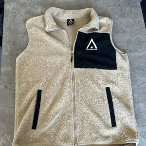 Beige fleeceväst från WearColour - Säljer en snygg pälsväst, sitter bra, aldrig använt, och mycket bra skick, perfekt nu till hösten, hör av er!
