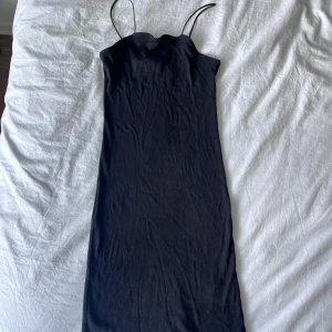 Svart stretchig klänning  - Svart stretchig klänning med spaghetti band. 