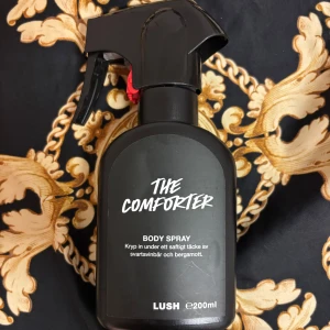 The Comforter Body Spray från Lush - Ca 65-60% kvar. En svart sprayflaska med The Comforter Body Spray från Lush. Doften har inslag av svartvinbär och bergamott. Flaskan rymmer 200 ml och har en praktisk sprayfunktion. Perfekt för dig som gillar fruktiga och fräscha dofter. Parfymer från Lush är starka och högkvalitativa och håller väldigt länge. Behövs inte många sprut alls för att lukta gott hela dagen eller två. 