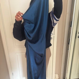 Blå långklänning i satin - Säljer en satin klänning one shoulder, perfekt för en bal eller en fest.