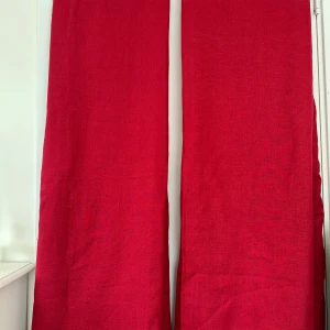Två röda gardiner - Två superfina röda gardinlängder i linne från IKEA, modell AINA. Varje gardin har en bredd på 145 cm och en höjd på 251 cm. Praktiska insydda dolda band för gardinskenan på baksidan. Välsydda och i nästan nyskick (hängts en gång)  Superfina, men passar inte in här tyvärr.   Hämtas i Stockholm eller skickas mot porto. 