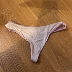 Ljusrosa bikiniunderdel från Bik Bok - Säljer en ljusrosa bikiniunderdel från Bik Bok i storlek XS. Tappat färgen lite, därav priset! Modellen har en enkel och stilren design med låg midja och smala sidor. Materialet är mjukt och stretchigt för en bekväm passform.