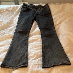 Svarta bootcut jeans från Gina tricot  - Säljer ett par svarta bootcut jeans från Gina tricot . Jeansen har klassisk femficksdesign, knapp och dragkedja framtill samt utsvängda ben. Perfekta för dig som gillar en retroinspirerad look.