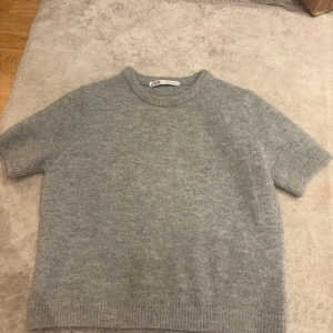 Grå stickad kortärmad tröja från ZARA - Säljer en helt oanvänd Zara tröja som är storlek M men passar mig som har xs-s