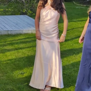 Rosa satin balklänning  - Säljer en jätte snygg rosa balklänning med halterneck och öppen rygg💕 Den är i nyskick utan några defekter alls , använd en gång. Den sitter super bra och är väldigt skön!! Jag är lite osäker på storleken men tror att det är storlek 34. Jag är 160 cm lång och den snuddar marken💕Jag betalade drygt 950 kr inkl frakt från själva företaget. Skriv om några frågor!! 