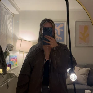 Brun oversized skinnjacka - Säljer en brun oversized skinnjacka med klassisk krage och resår vid ärmslut och nederkant. Jackan har en enkel design utan synliga detaljer som knappar eller dragkedja framtill. 🧚🏽