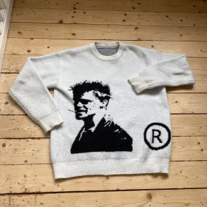 Vit stickad tröja med Tyler durden  - Vit stickad tröja med Tyler durden och rund halsringning. Tröjan har långa ärmar. Den har en n Unik design med stor svart bild på framsidan och ett R-symbol. ( den är extremt bekväm och snygg)